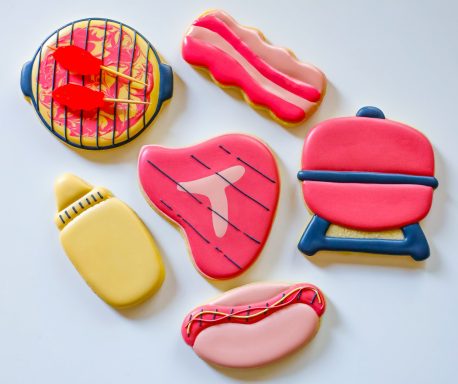 Colorful cookies shaped like barbecue items, including a grill, hot dog, steak, and mustard.